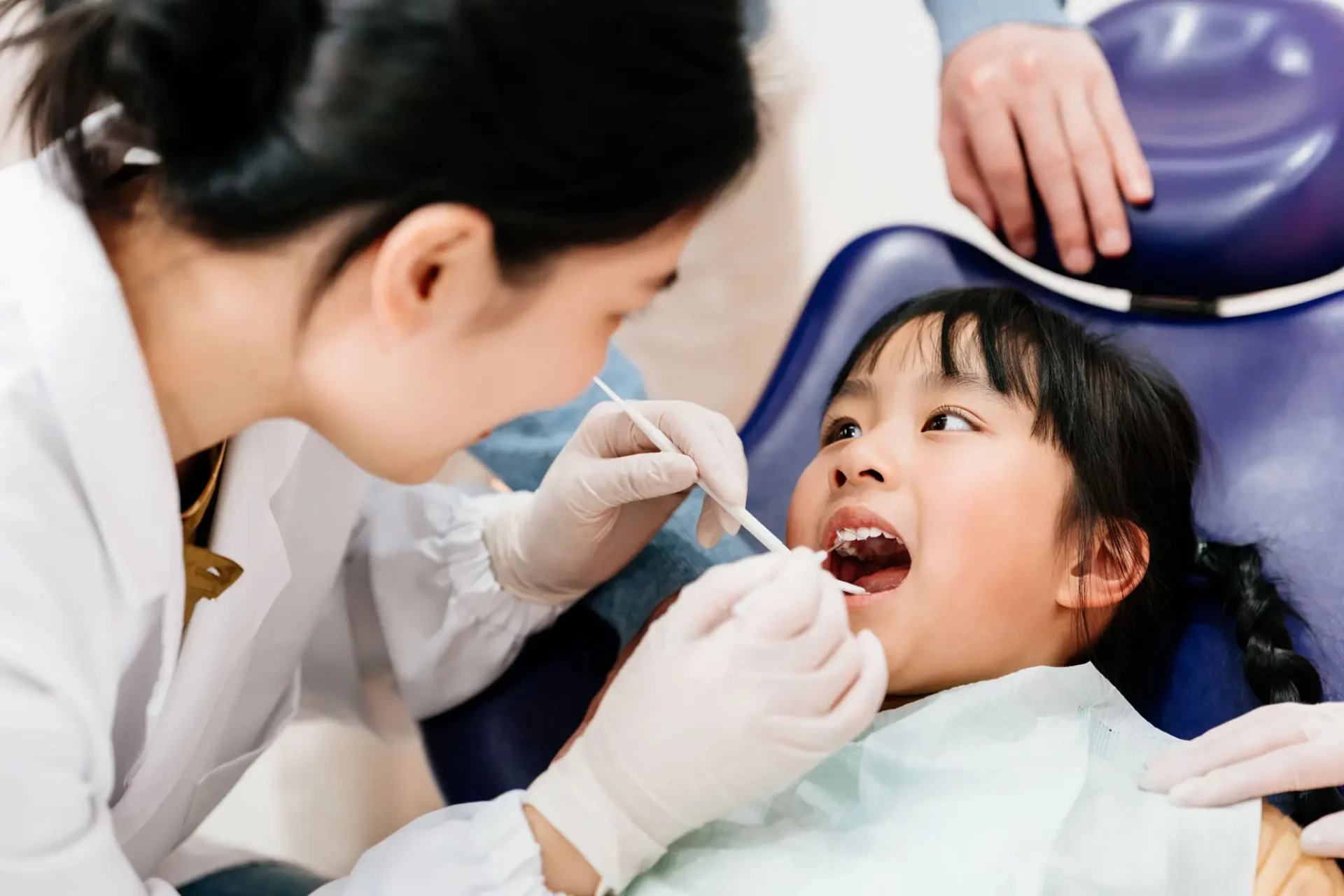 Child receiving dental checkup from dentist.