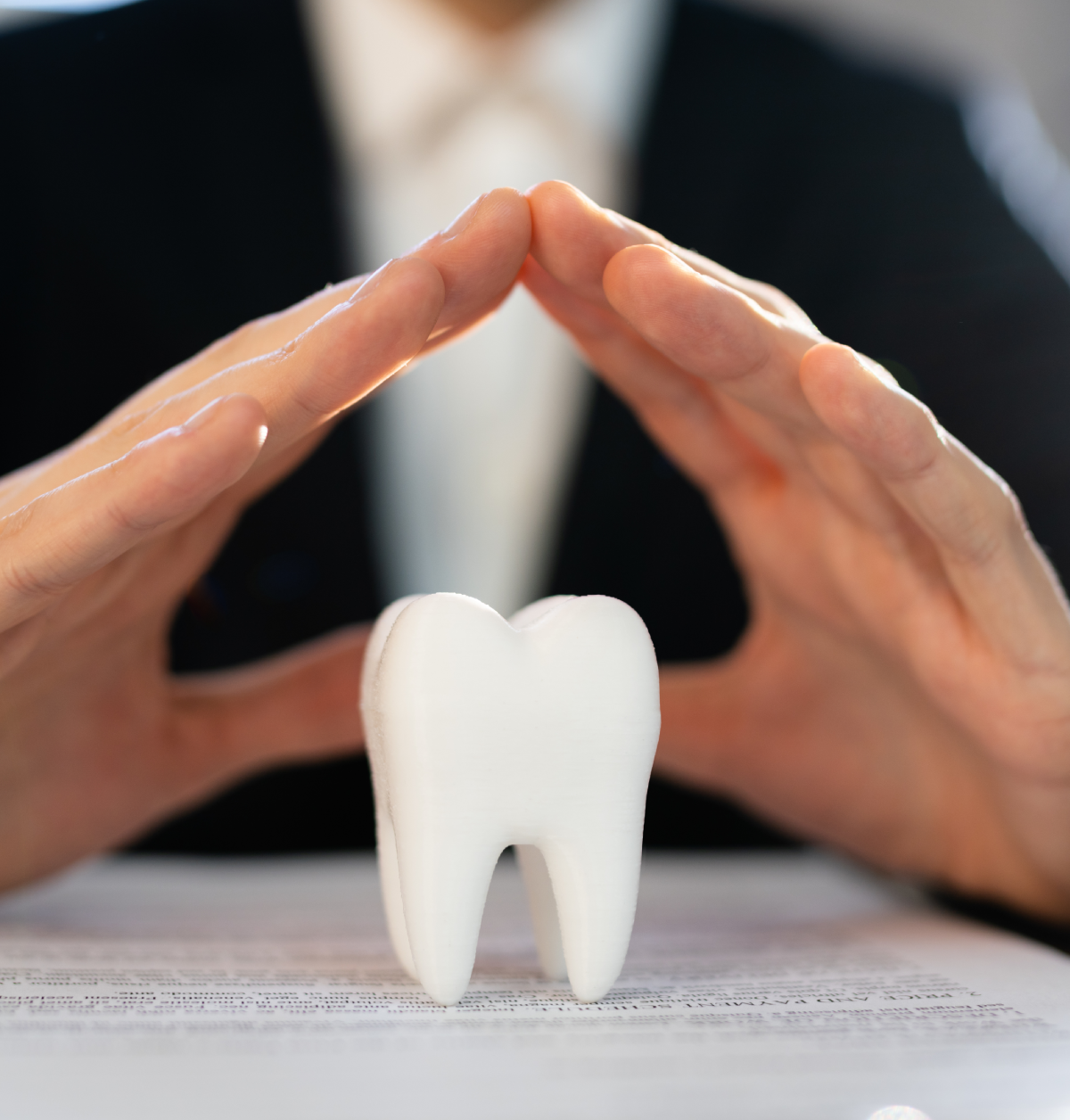 Hands protecting a tooth model