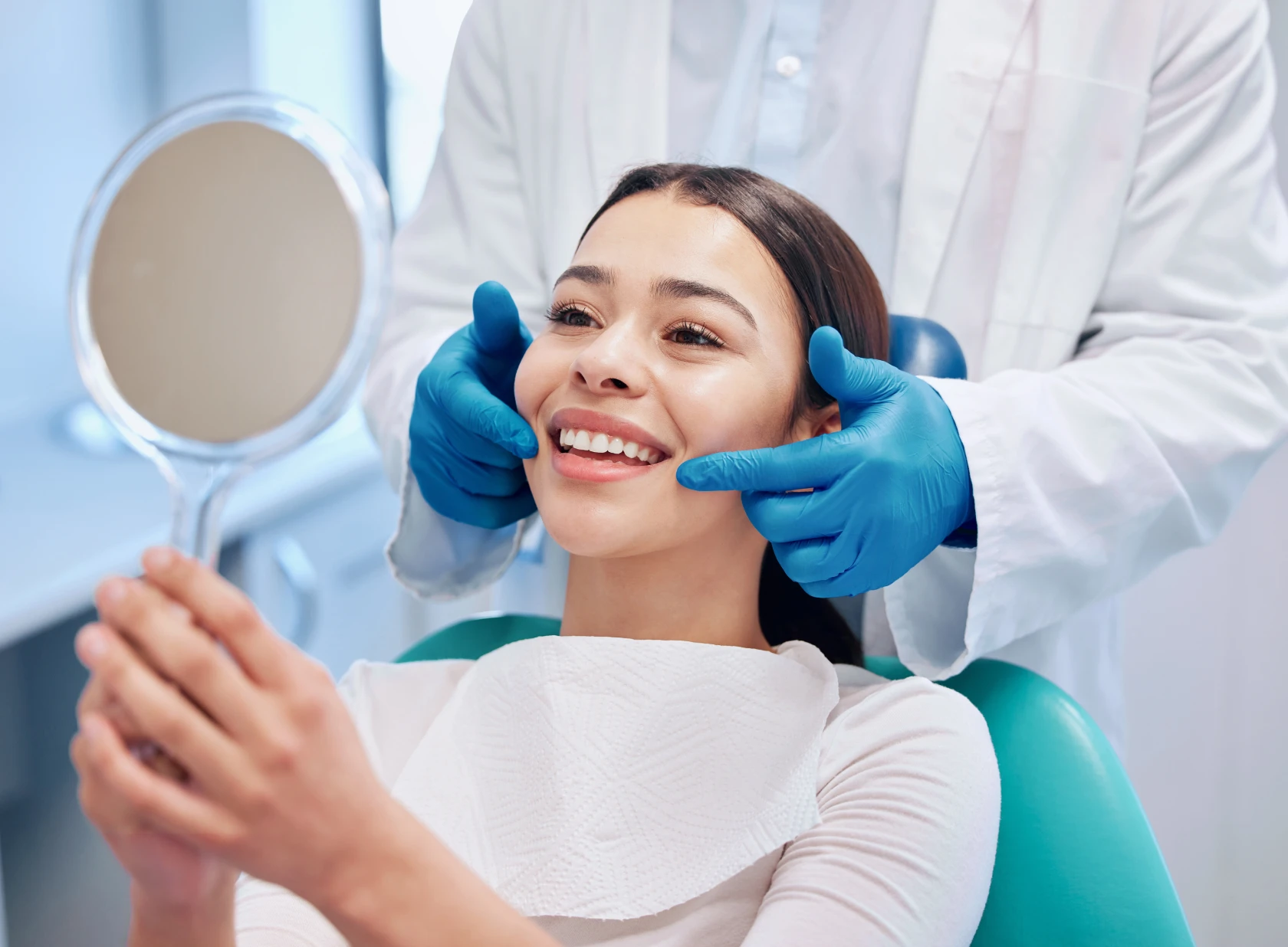 Patient holding mirror, smiling dentist visit