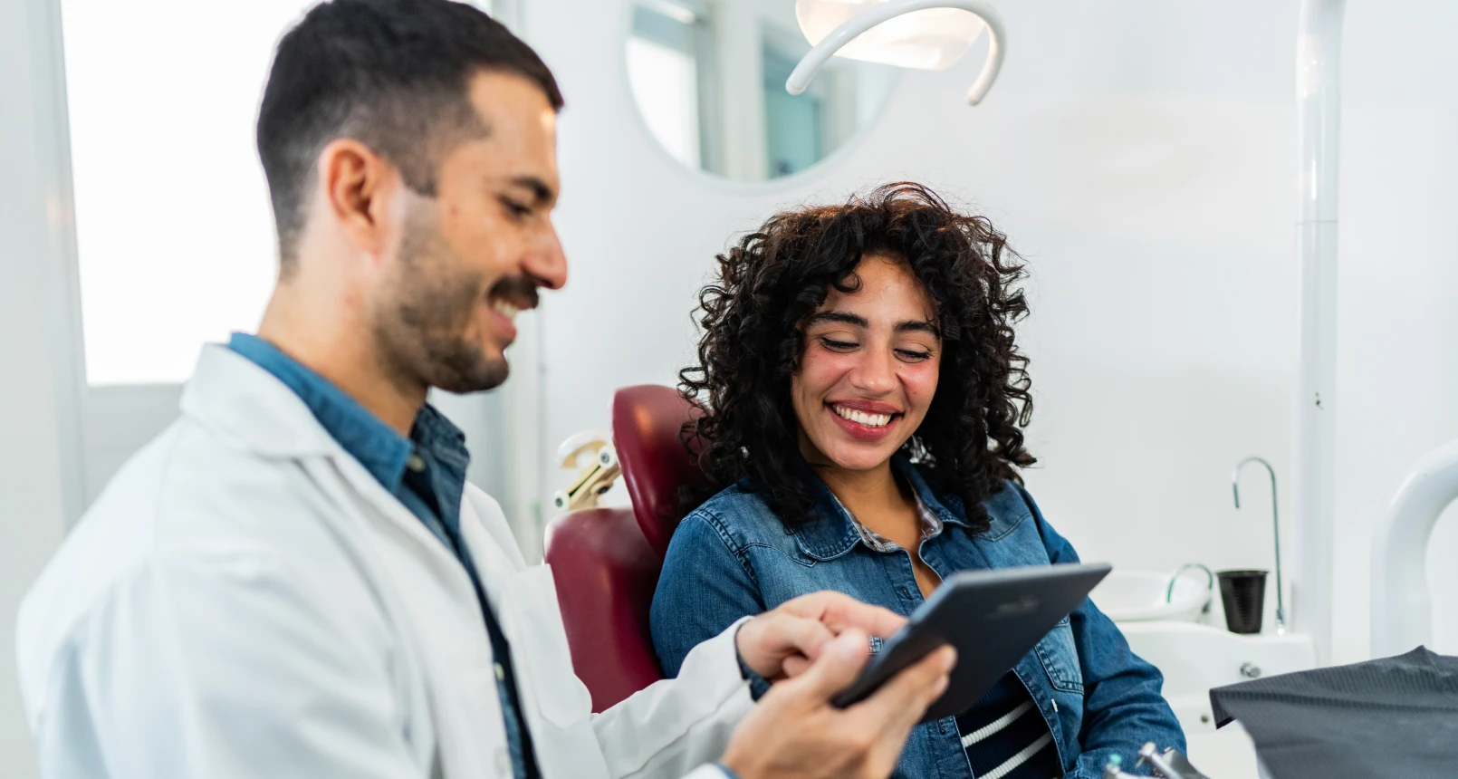 Dentist and patient smiling during consultation
